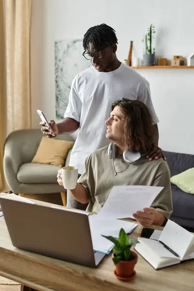 Two partners share a warm moment at home while engaging in their daily activities. — Stock Photo