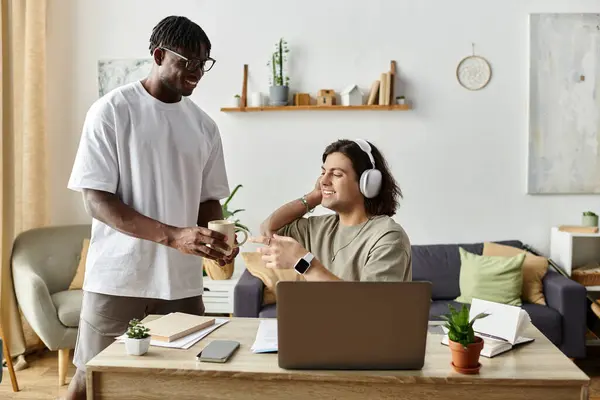 Dos socios se deleitan mutuamente mientras se dedican a actividades diarias en casa. - foto de stock