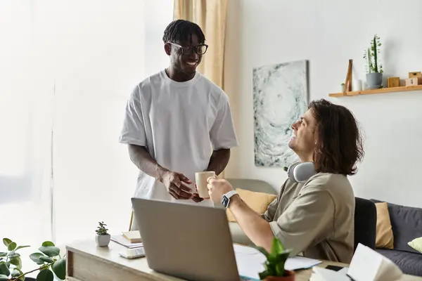 Two partners enjoy each other at home while sharing a warm cup and smiles. — Stock Photo