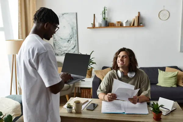 Two partners share a cozy moment at home, engaging in work while connecting and smiling. — Stock Photo