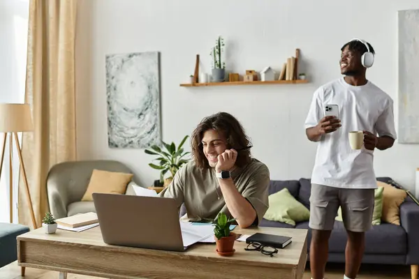 Two partners cherish a relaxed day at home, one engaged in work while the other enjoys a drink. — Stock Photo