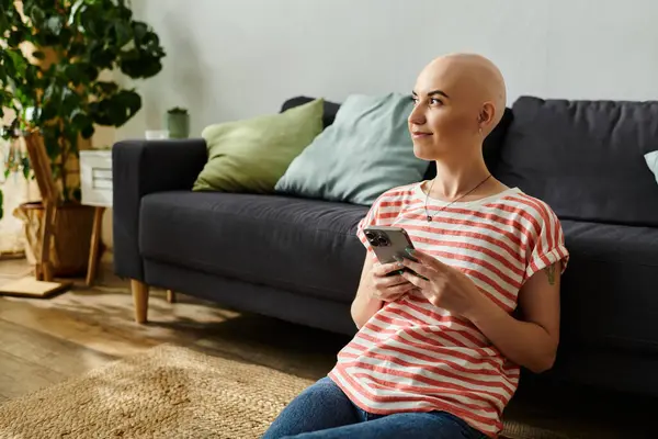 A calm young woman enjoys her smartphone on the floor, radiating confidence in her unique style. — Stock Photo
