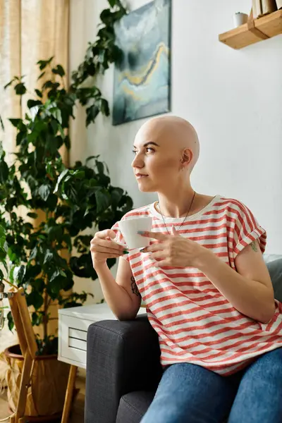 A young woman with alopecia peacefully sips tea amidst a beautifully decorated room. — Stock Photo