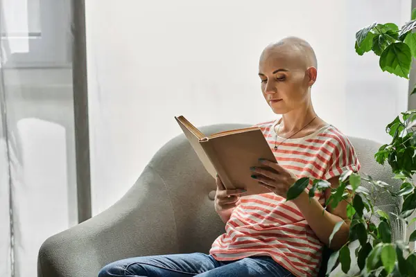 Ein heiterer Moment fängt eine glatzköpfige Frau ein, die sich in einem Buch verliert und die Ruhe im Haus genießt. — Stockfoto