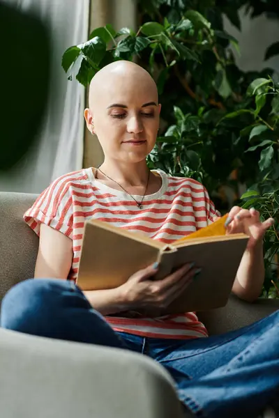 A young woman with alopecia reads intently, surrounded by lush greenery and natural light. — Stock Photo