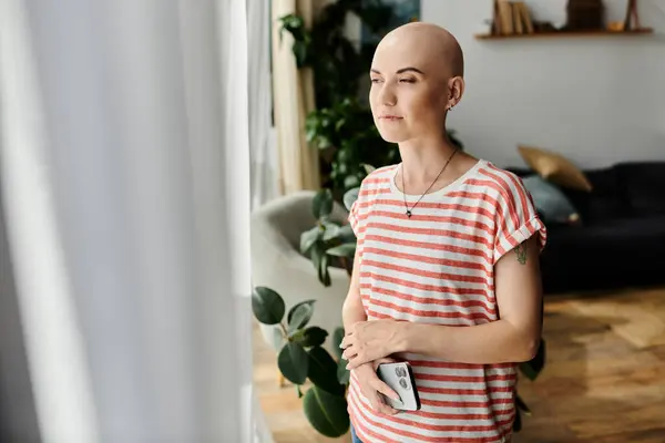 A woman stands pensively by the window, showcasing her unique beauty and strength. — Stock Photo