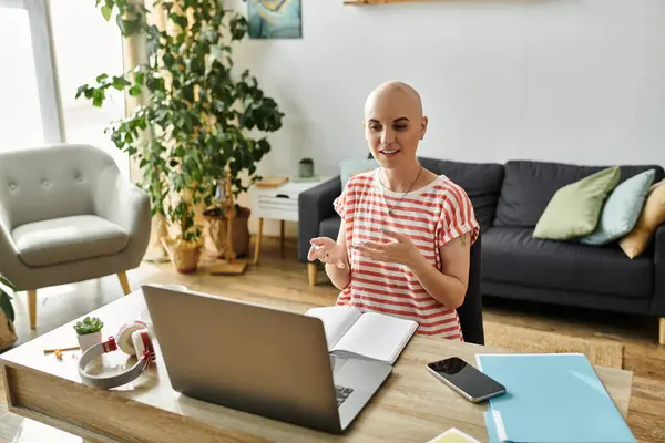 Una mujer calva vibrante con alopecia comparte ideas mientras está sentada en su escritorio, enriqueciendo la atmósfera. — Stock Photo