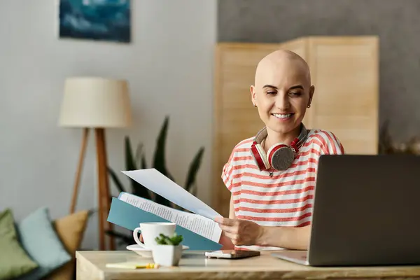 The bald woman smiles while organizing materials at her modern desk, surrounded by greenery. — Stock Photo