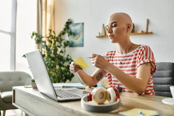 She thoughtfully organizes notes while seated at a stylish desk surrounded by greenery. — Stock Photo