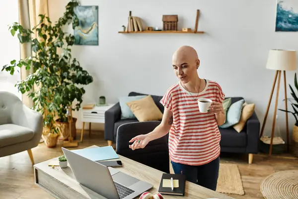 Sunlight streams into a cozy room as a young woman sips coffee and uses her laptop. — Stock Photo