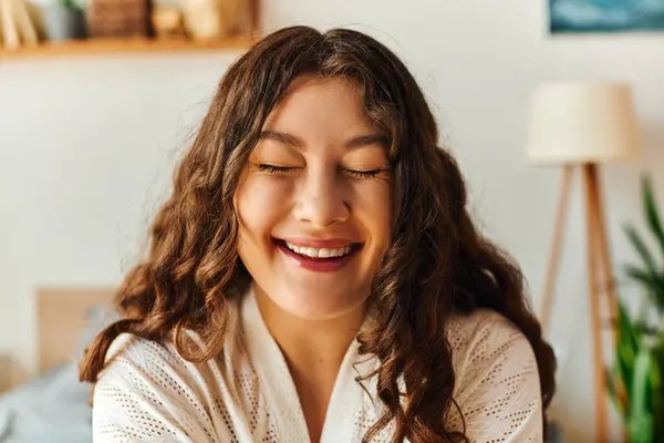 A young beautiful plus size woman smiles brightly while relaxing in her comfortable home. — Stock Photo