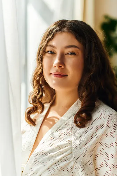 Une jeune belle femme plus la taille rayonne de joie tout en se prélassant à la lumière du soleil à l'intérieur. — Photo de stock