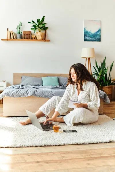 A young beautiful plus size woman enjoys a relaxed day working on her laptop in a cozy room. — Stock Photo