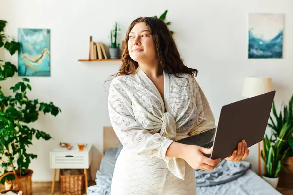 A confident young woman engages with her laptop, feeling relaxed and at home. — Stock Photo