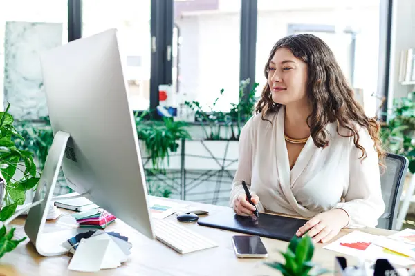 A young, beautiful plus size woman enjoys her creative time at office surrounded by greenery. — Stock Photo