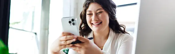 The young beautiful woman smiles brightly while using her smartphone, radiating happiness. — Stock Photo