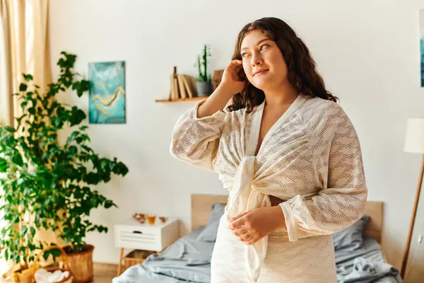 Une jeune femme de plus de taille se tient soigneusement dans sa chambre élégante, entourée de verdure. — Photo de stock
