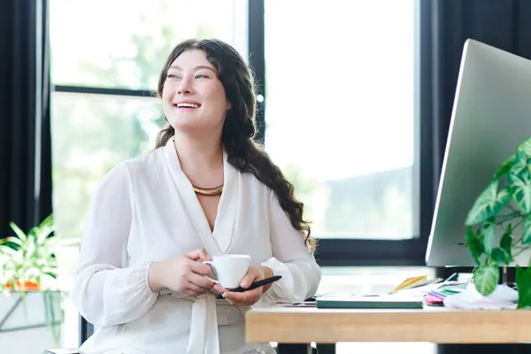 The young woman relaxes at office, savoring coffee and basking in natural light. — Stock Photo