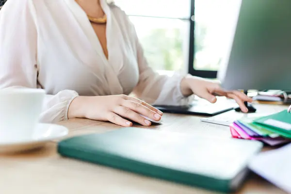 Une femme de taille plus se concentre sur son travail au bureau entouré de papeterie colorée et d'une tasse. — Photo de stock