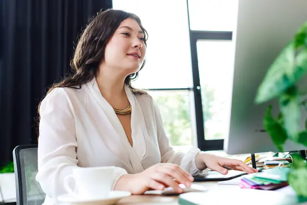 Bright sunlight fills the cozy office as a plus size woman engages in her work, smiling. — Stock Photo
