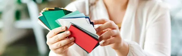A young beautiful plus size woman enjoys a variety of colorful cards while relaxing at office. — Stock Photo