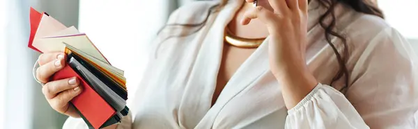 In a cozy office, a beautiful plus size woman thoughtfully explores vibrant color swatches. — Stock Photo