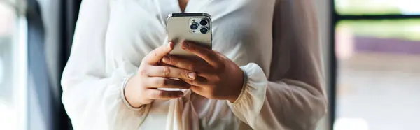 A young beautiful plus size woman holds her phone, enjoying a peaceful moment at office. — Stock Photo
