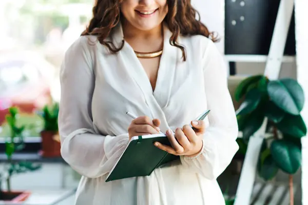 A young beautiful woman captures her thoughts on paper while enjoying a bright office atmosphere. — Stock Photo