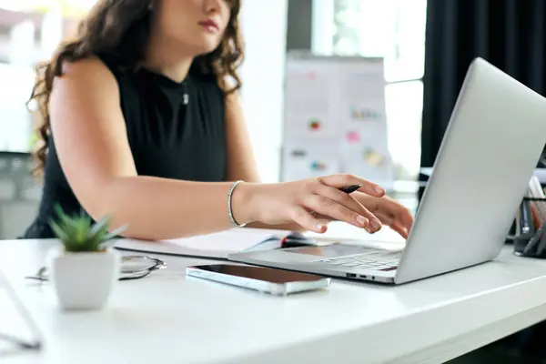 A young, plus-size professional with curly hair focuses on her tasks, actively collaborating at her modern office space. — Stock Photo