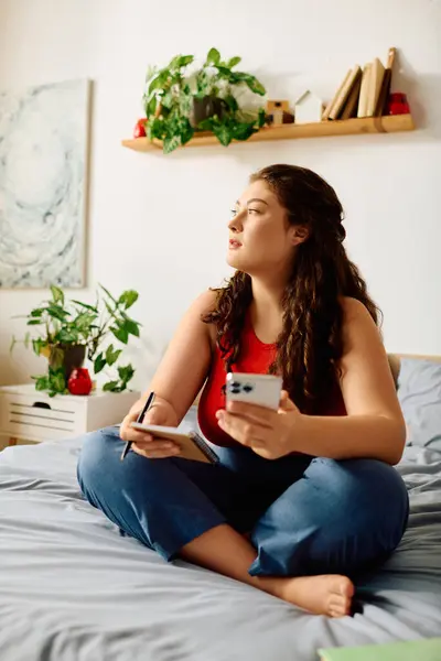 Eine junge Plus-Size-Frau entspannt sich auf ihrem Bett und macht sich Gedanken, während sie von heimeliger Dekoration und Pflanzen umgeben ist. — Stockfoto