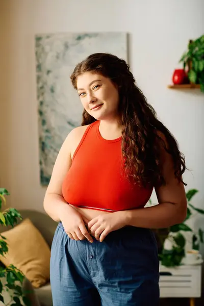 Une jeune femme dynamique se prélasse à la maison, mettant en valeur ses cheveux bouclés tout en se sentant détendue et confiante. — Stock Photo