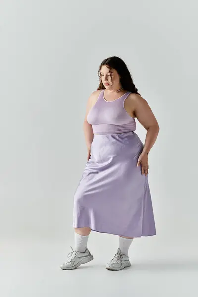 The elegant plus size woman stands poised in a lavender dress, radiating confidence and beauty. — Stock Photo