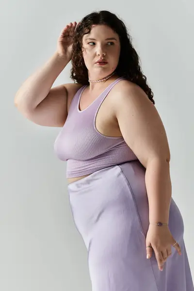 Uma mulher plus size mostra sua elegância em roupas macias de lavanda enquanto golpeia uma pose confiante. — Fotografia de Stock
