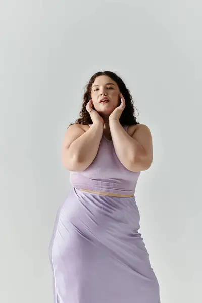A confident woman showcases her beauty in a chic lavender ensemble, posing with poise. — Stock Photo
