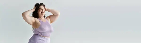 A confident plus size woman radiates joy while playfully posing with her hands in her hair. — Stock Photo