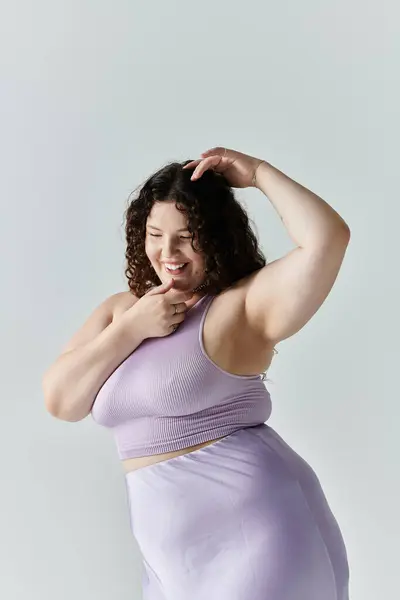 A confident plus size woman shines in a stylish lavender outfit, embracing her beauty. — Stock Photo