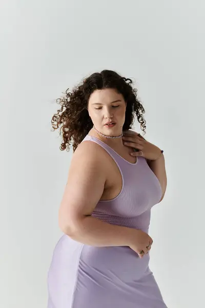A beautiful plus size woman twirls gently, showcasing her confidence in a pastel lavender dress. — Stock Photo