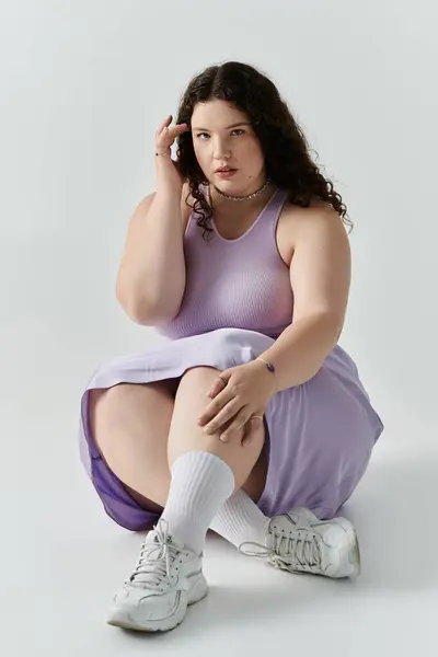 A beautiful plus size woman showcases her confidence and elegance while dressed in soft pastel hues. — Stock Photo