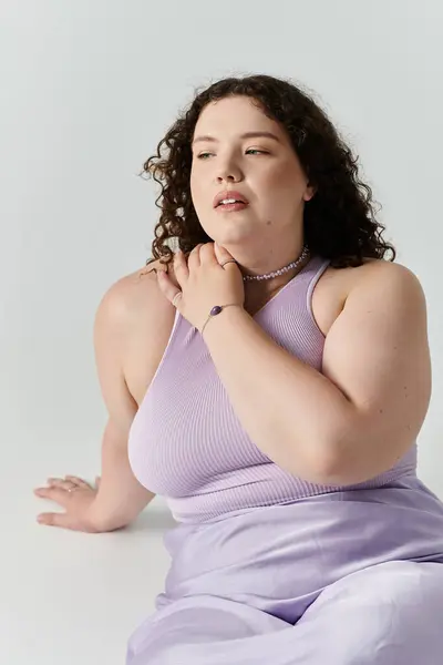 Una hermosa mujer abraza sus curvas con confianza, exudando elegancia en colores pastel. - foto de stock