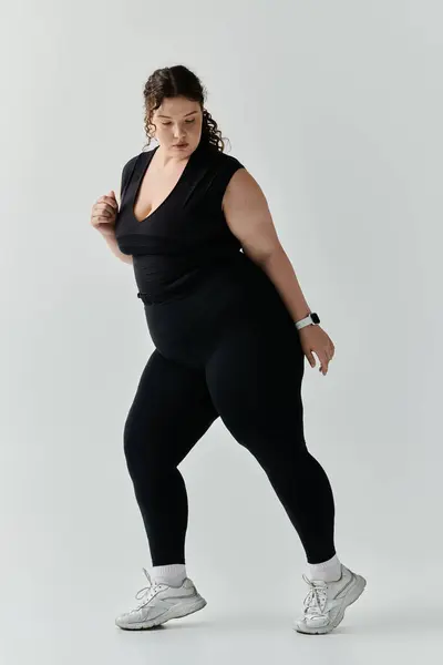 A stylish plus size woman expresses beauty and confidence in a contemporary indoor space. — Stock Photo