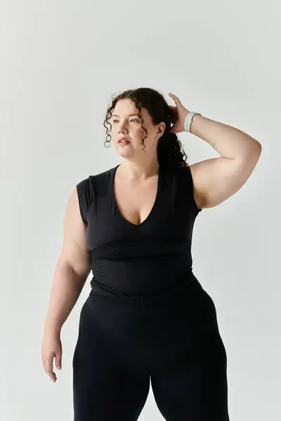 Красивая женщина plus size демонстрирует свою красоту в стильном наряде, излучая уверенность. — стоковое фото