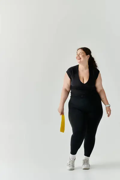 A beautiful plus size woman enjoys her moment in a bright, open studio space, smiling brightly. — Stock Photo