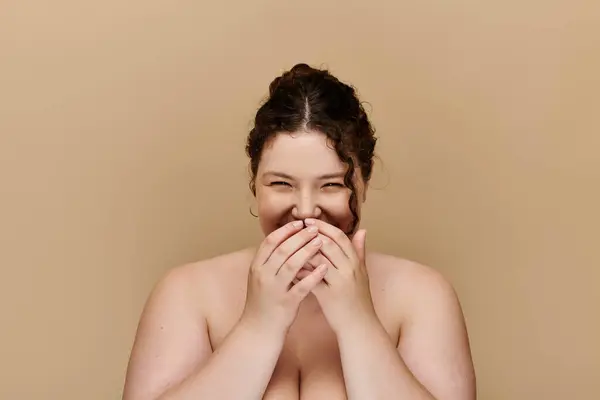 A beautiful plus size woman joyfully covers her mouth, radiating confidence and charm. — Stock Photo