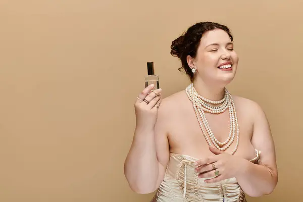 Uma mulher elegante irradia confiança enquanto segura seu perfume, adornado em pérolas. — Fotografia de Stock