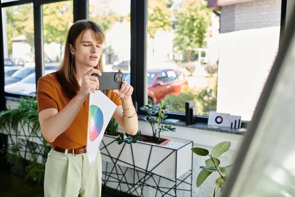 A young non binary individual engages with colorful design concepts while in an office. — Stock Photo