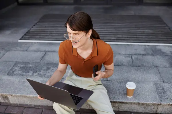 This young non binary individual is focused on their laptop while enjoying coffee in the office. — Stock Photo