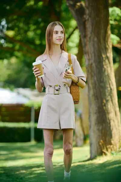 A young woman with anorexia embraces her daily life outdoors, sipping coffee under the trees. — Stock Photo