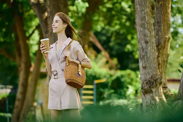 A young woman with anorexia embraces a sunny day outdoors, feeling happy while sipping a warm drink. — Stock Photo
