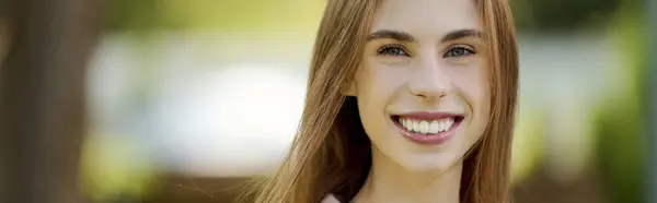 Una giovane donna allegra abbraccia la natura, irradiando gioia mentre si gode la vita all'aria aperta, mostrando la sua forza e resilienza. — Foto stock