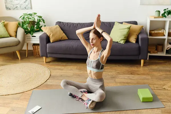 Una giovane donna dedicata con anoressia si impegna in una rilassante sessione di yoga a casa, concentrandosi sulla sua salute fisica e mentale. — Foto stock